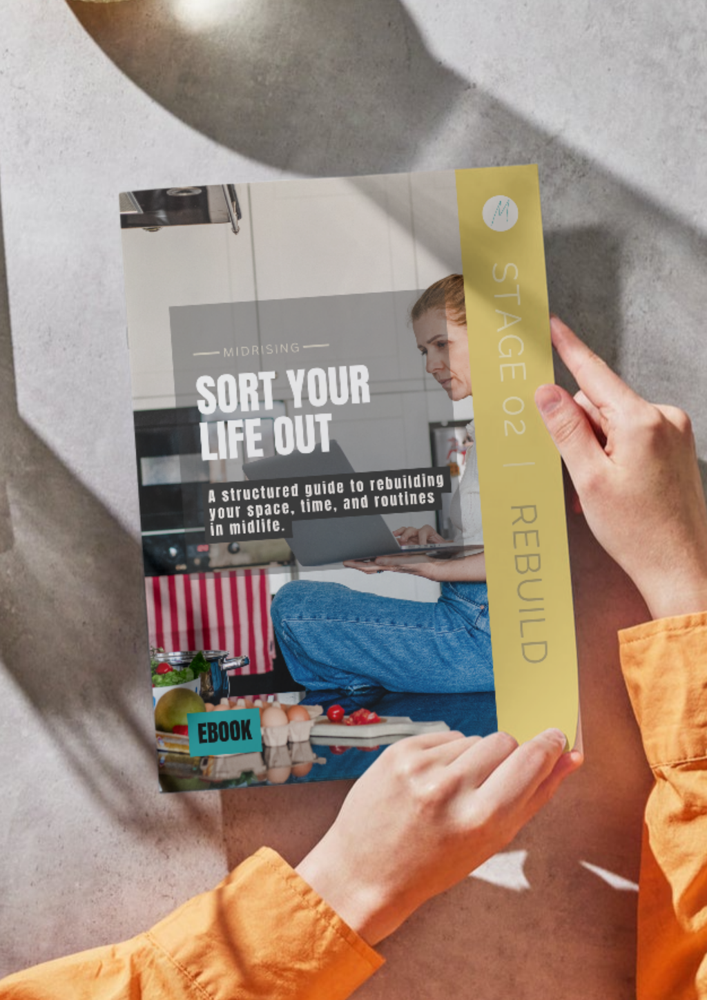 Sort Your Life Out Midrising ebook shown as a booklet in hand — a guide for Gen X women rebuilding their routines in midlife. Stage 02 Rebuild.